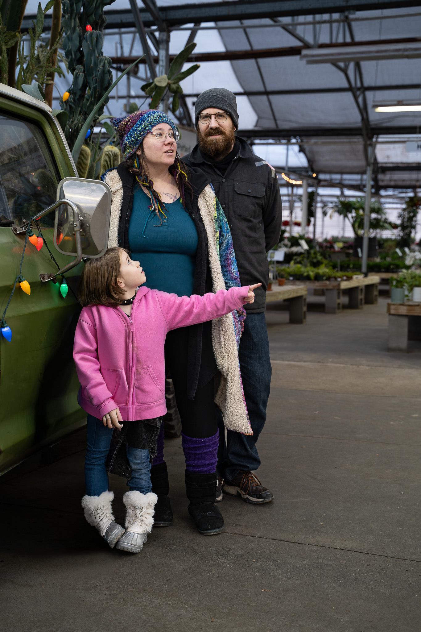 Portrait of a family standing in front of a green truck with plants in the background. Lyssa Benavidez Photography Elkhorn, NE Lyssab.com Lifestyle family photography
